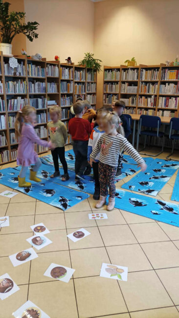 Nuka przez zabawę, czyli "Czytanie na dywanie". Przedszkolaki podczas zabawy aktywizującej w Bibliotece nr 53.