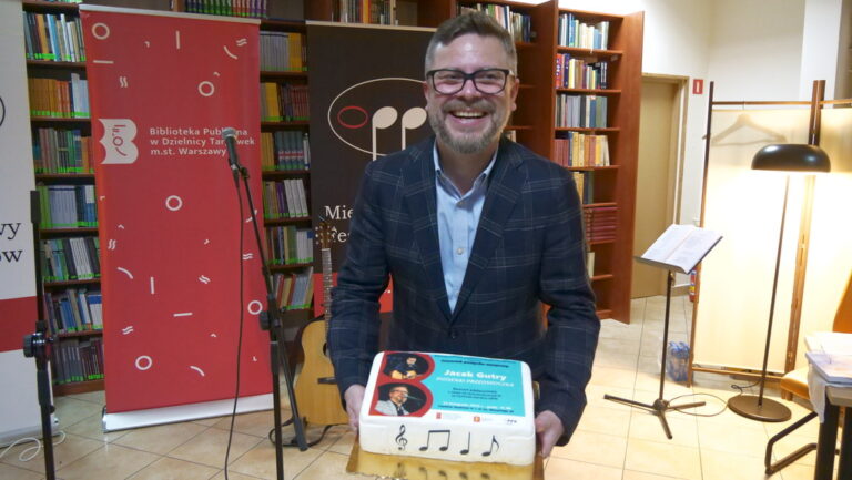 uśmiechnięty Jacek Gutry z tortem