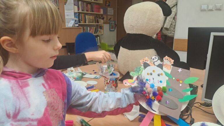 dziewczynka pokazuje swoją pracę plastyczną
