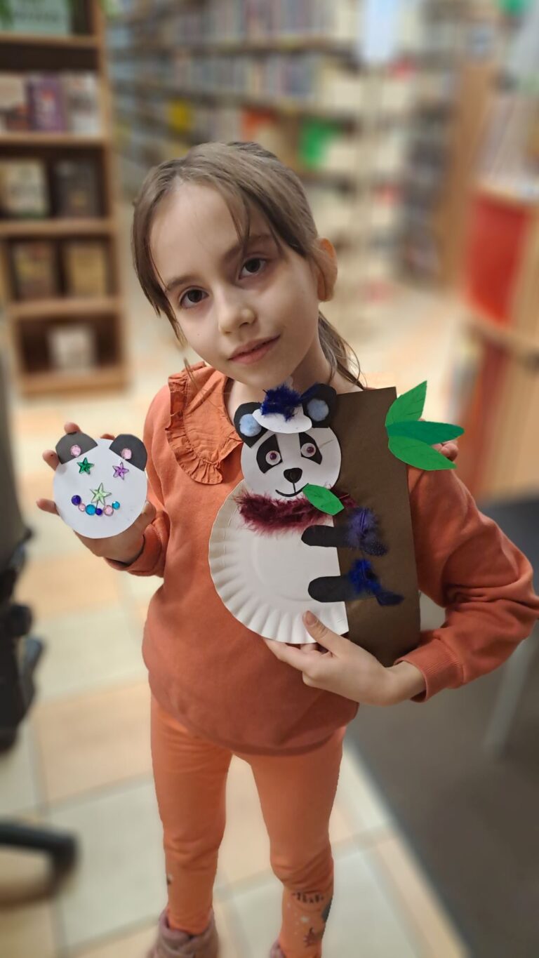 dziewczynka pokazuje swoją pracę plastyczną