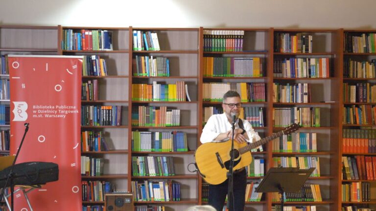 artysta śpiewa i gra na gitarze