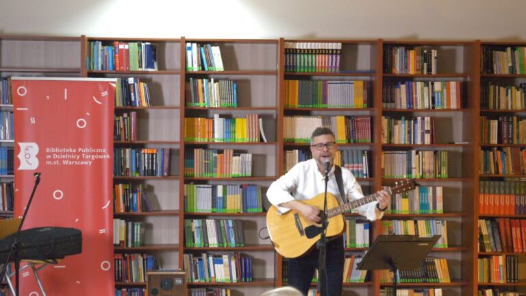 artysta śpiewa i gra na gitarze