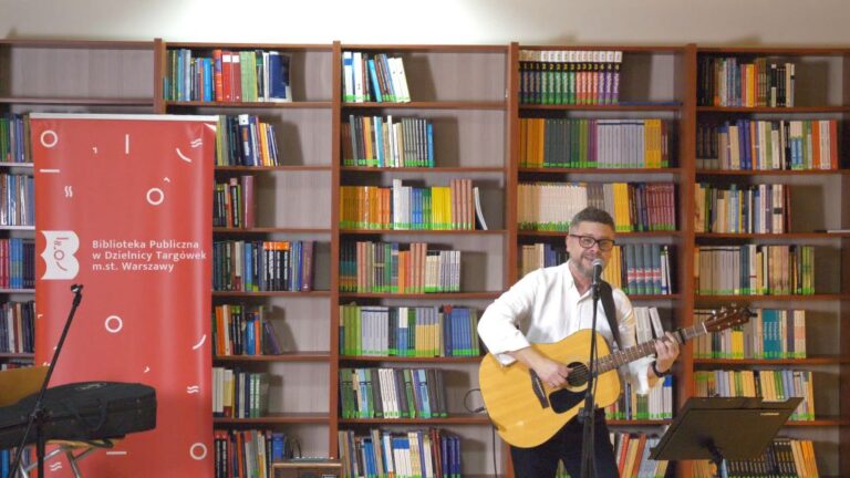 artysta śpiewa i gra na gitarze