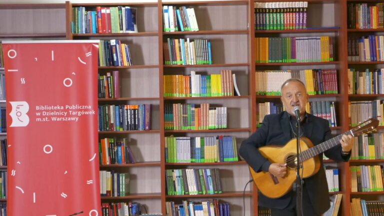 artysta śpiewa i gra na gitarze