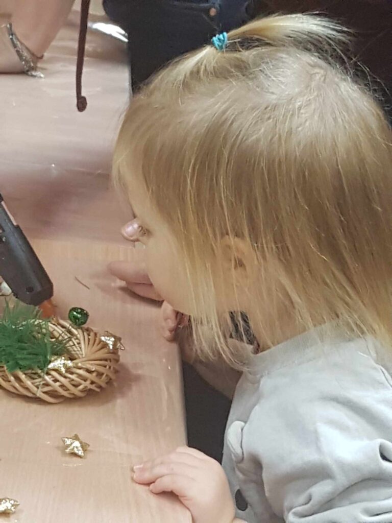 dziewczynka podziwia świąteczny wianek