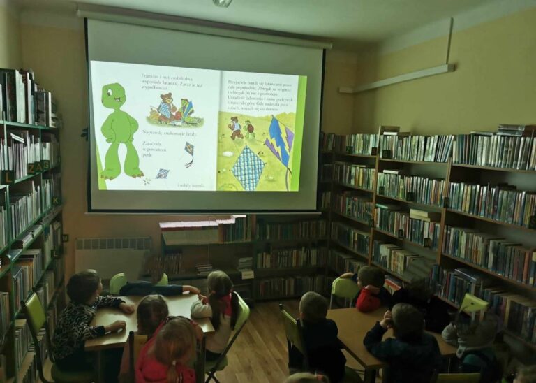 dzieci oglądają książkę o Franklinie na ekranie projektora
