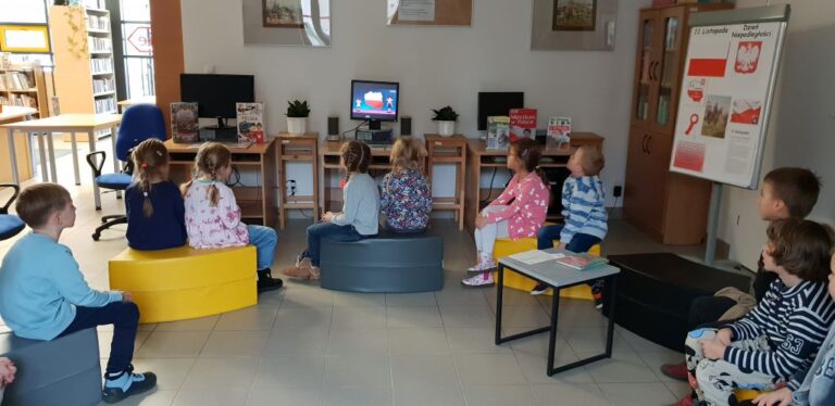 dzieci oglądają w bibliotece bajkę patriotyczną