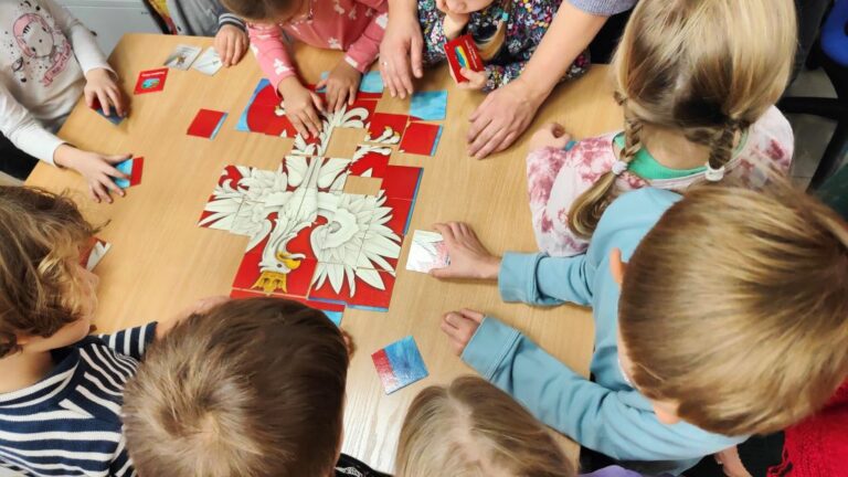 dzieci układają z puzzli godło Polski