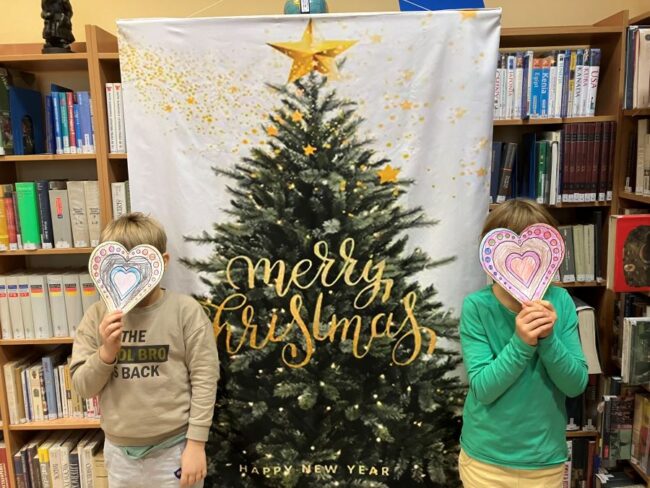 dzieci trzymają swoje prace plastyczne - serduszka