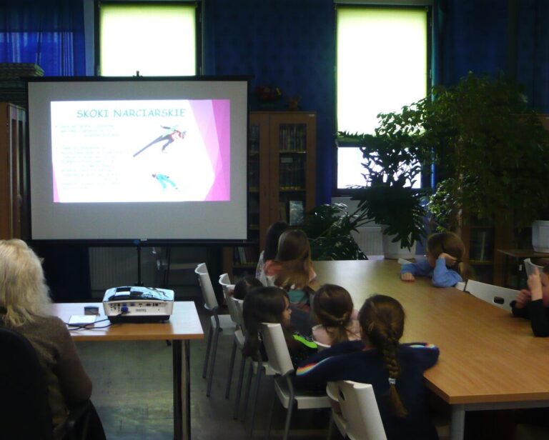 dzieci oglądają prezentację multimedialną o sportach zimowych