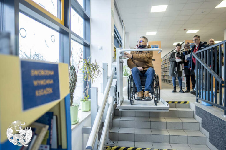 mężczyzna na wózku przemieszcza się na windzie dla wózków w bibliotece