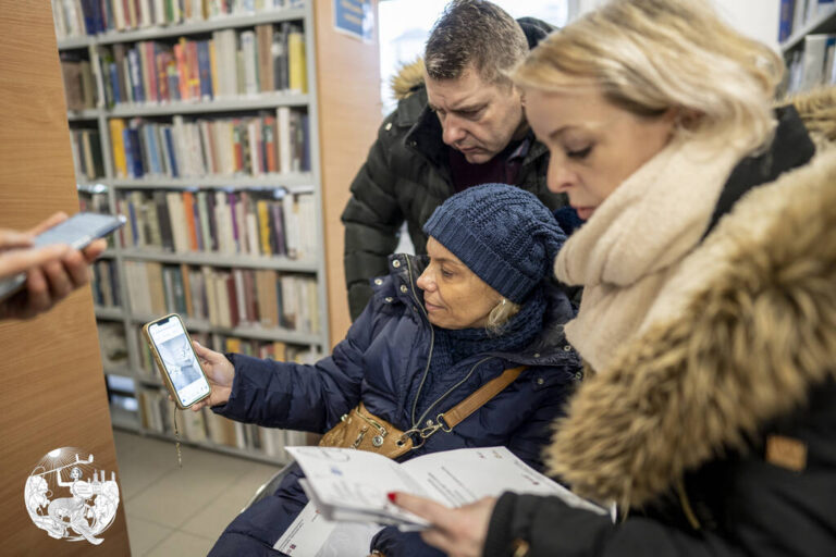 grupa osób szuka informacji w smartfonie