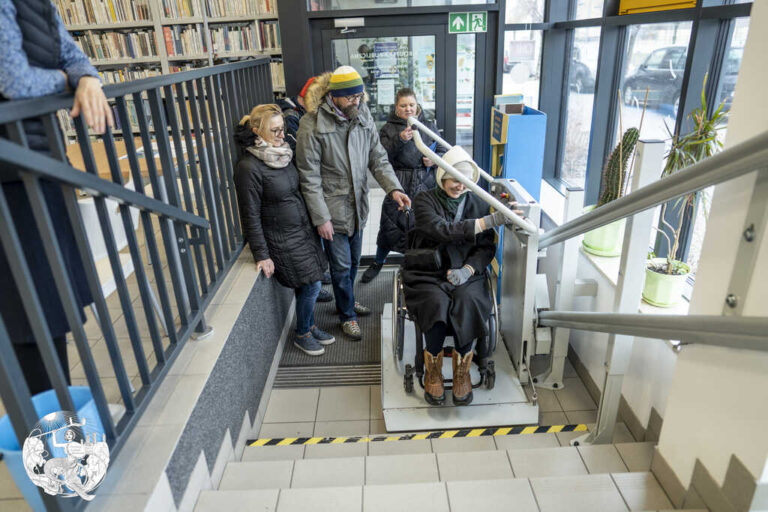kobieta na wózku przemieszcza się na windzie dla wózków w bibliotece