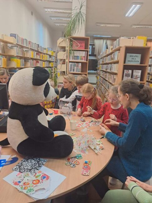 zajęcia biblioteczne dla dzieci, na stole maskotka pandy Wandy
