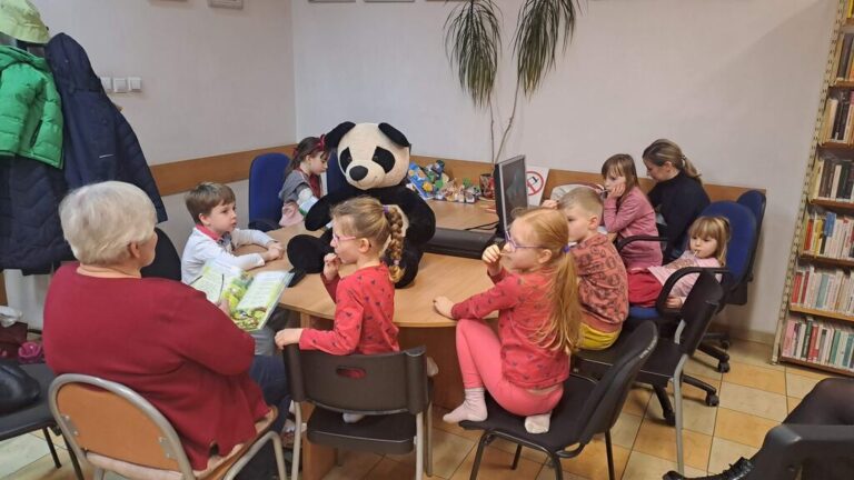 zajęcia biblioteczne dla dzieci, na stole maskotka pandy Wandy