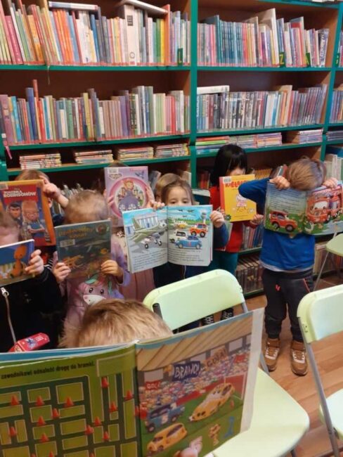 dzieci czytają książki w bibliotece
