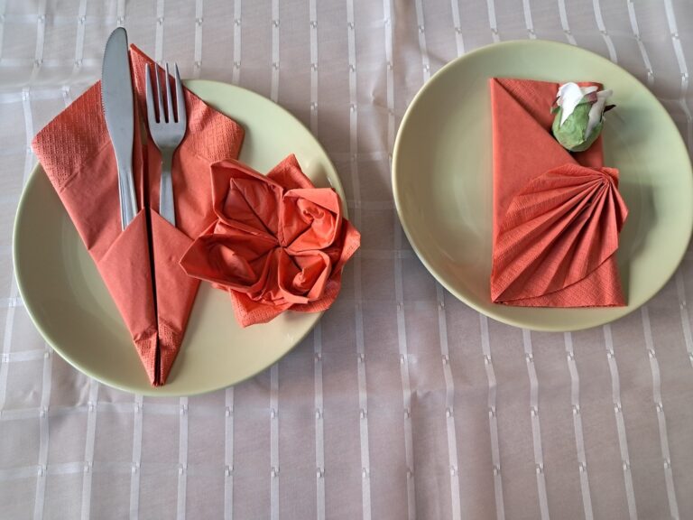fantazyjnie złożone serwetki leżące na talerzach