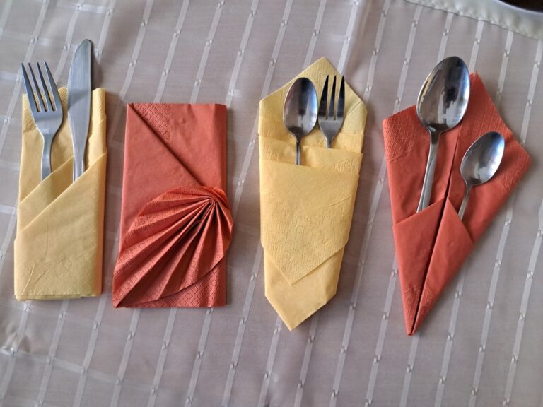 fantazyjnie złożone serwetki leżące na talerzach