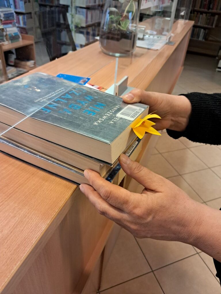 papierowe żonkile w bibliotece - symbol pamięci o powstaniu w getcie warszawskim