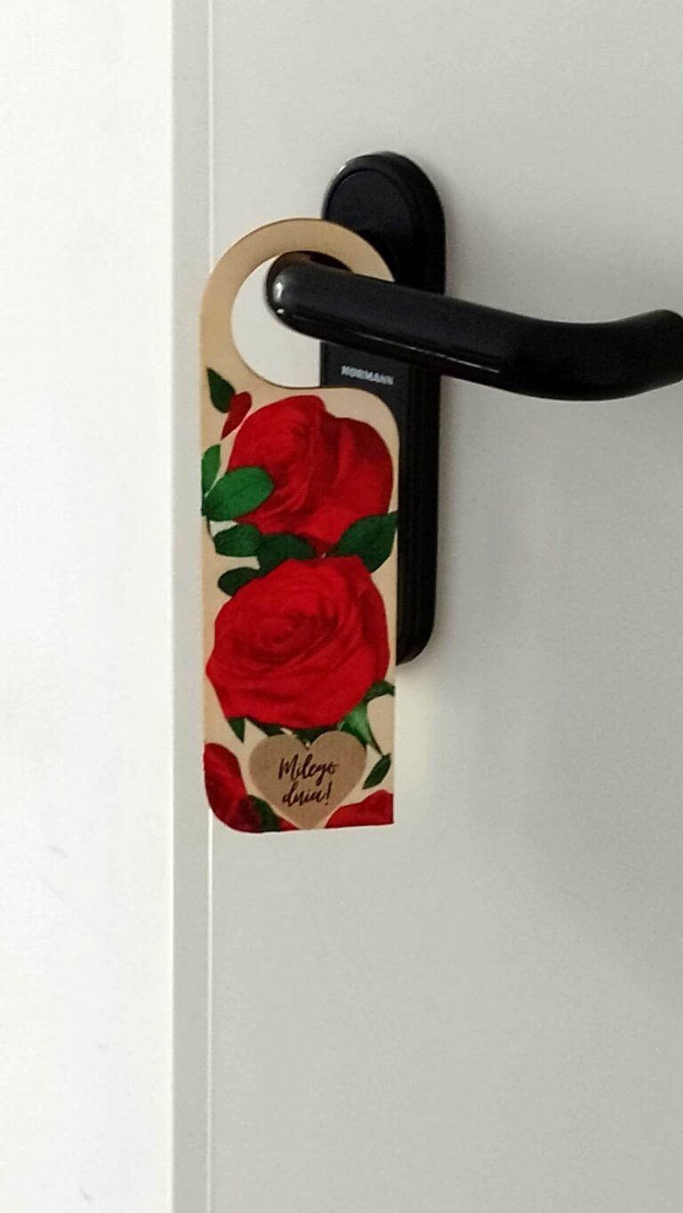 zawieszka ozdobiona kwiatami w technice decoupage wisi na klamce drzwi