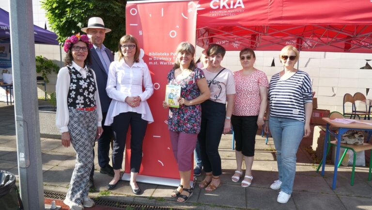 załoga biblioteki przy stoisku z książkami na festynie