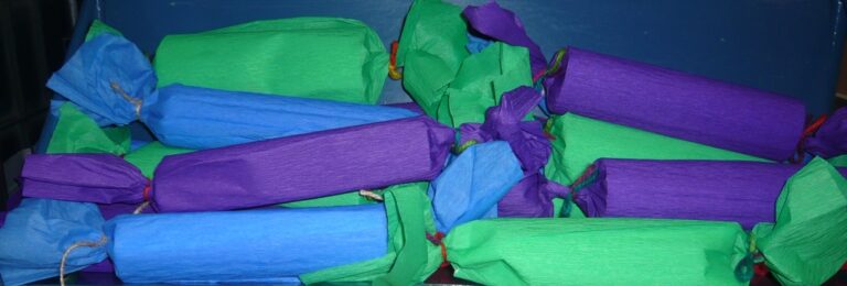 prezenty-niespodzianki opakowane w papier tak, że wyglądają jak duże podłużne cukierki