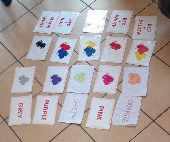 na podłodze leżą kartki ze słowami oznaczającymi kolory w języku angielskim