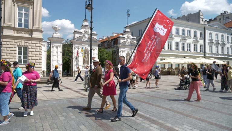 załoga biblioteki przechodzi obok bramy uniwersytetu warszawskiego