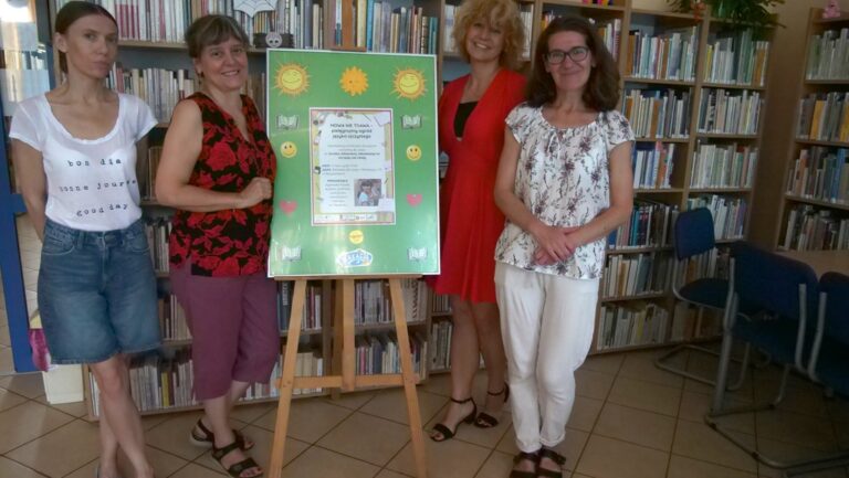 autorki projektu i kierowniczka biblioteki z bibliotekarką pozują do pamiątkowego zdjęcia przy plakacie promującym projekt Mowa nie trawa