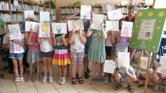 dzieci pokazują swoje prace plastyczne