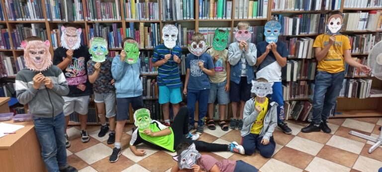 dzieci pokazują wykonane przez siebie maski