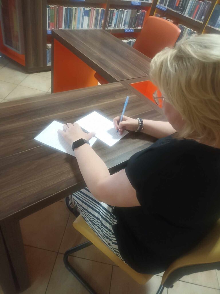 pracownik biblioteki odręcznie przepisuje wiersz Zbigniewa Herberta