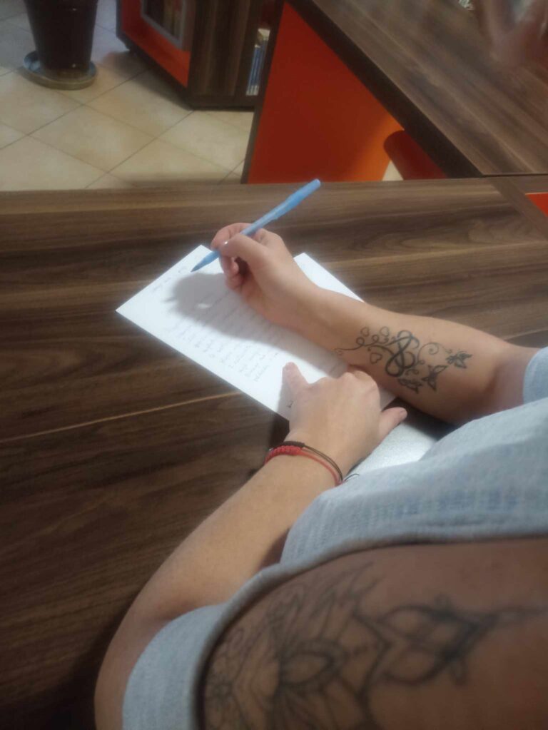 czytelniczka biblioteki odręcznie przepisuje wiersz Zbigniewa Herberta