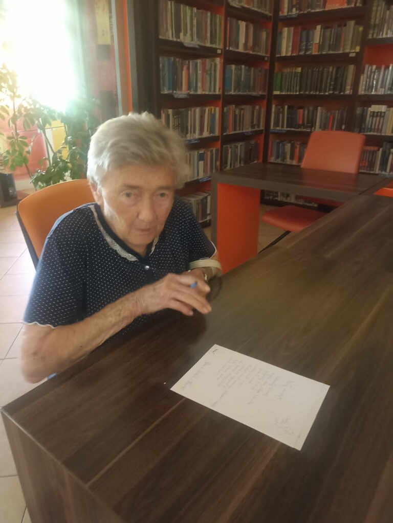 czytelniczka biblioteki odręcznie przepisuje wiersz Zbigniewa Herberta