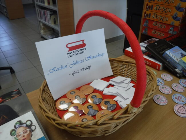 koszyk z pamiątkowymi przypinkami, dookoła książki