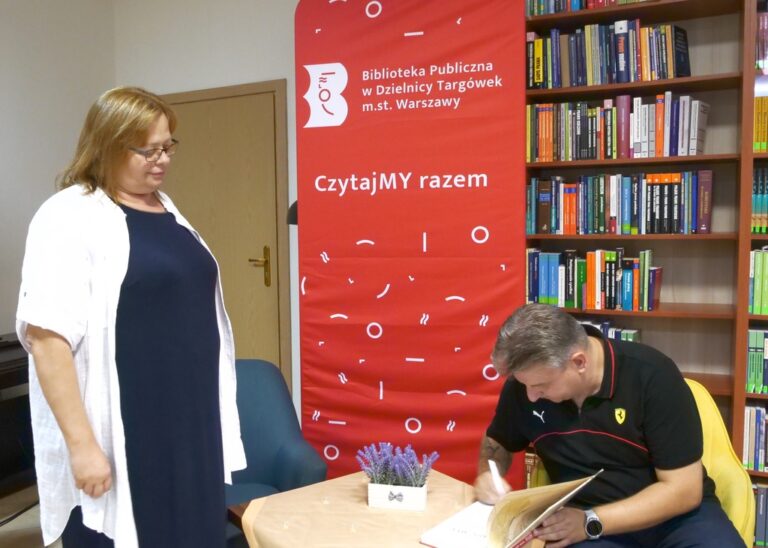 autor podpisuje książkę