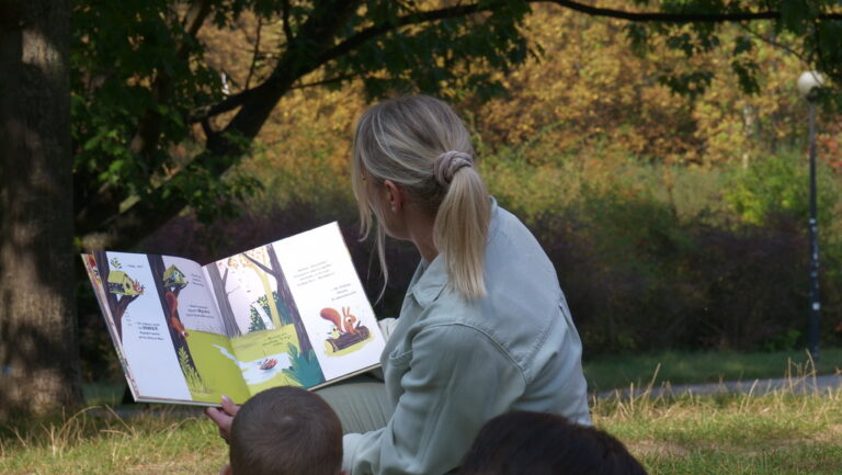 zajęcia biblioteczne dla dzieci; czytanie książki w parku brónowskim
