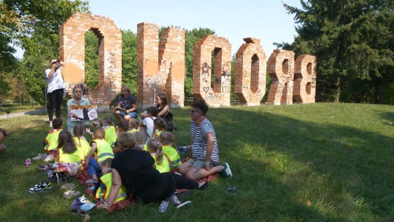 zajęcia biblioteczne dla dzieci; czytanie książki w parku brónowskim