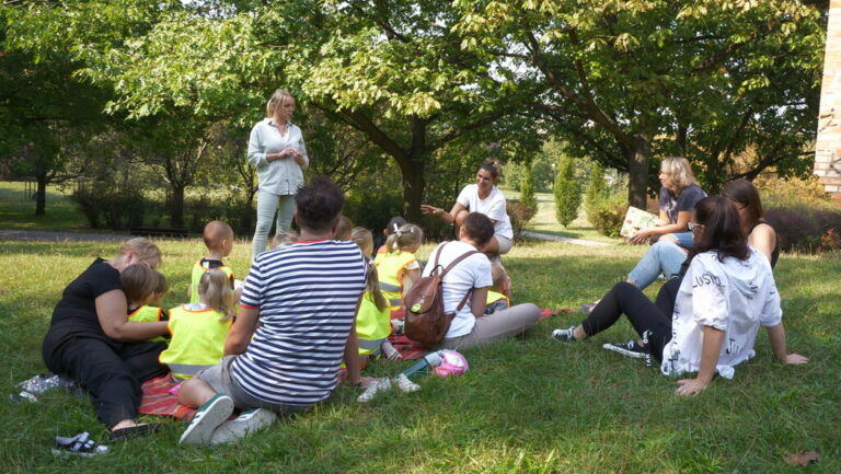 zajęcia biblioteczne dla dzieci; czytanie książki w parku brónowskim