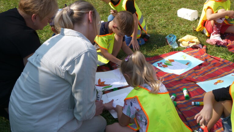 zajęcia biblioteczne dla dzieci; czytanie książki w parku brónowskim