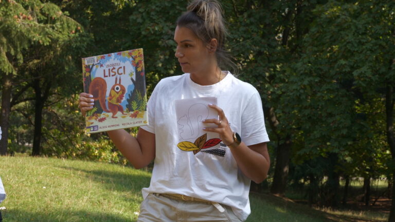 zajęcia biblioteczne dla dzieci; czytanie książki w parku brónowskim