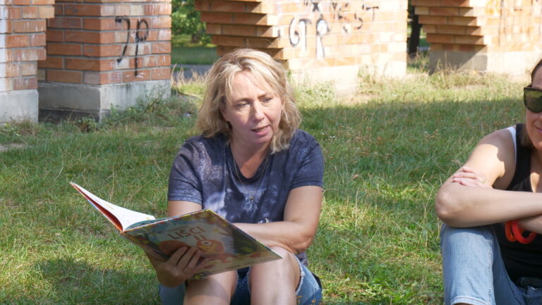 zajęcia biblioteczne dla dzieci; czytanie książki w parku brónowskim