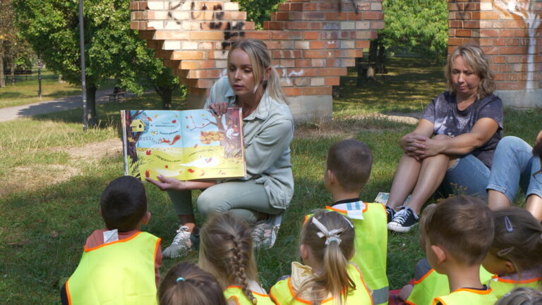 zajęcia biblioteczne dla dzieci; czytanie książki w parku brónowskim