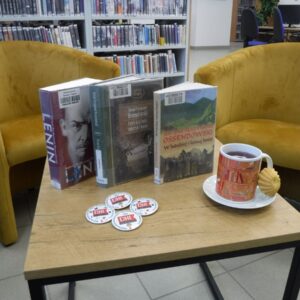 książki i filiżanka na stoliku, w tle książki