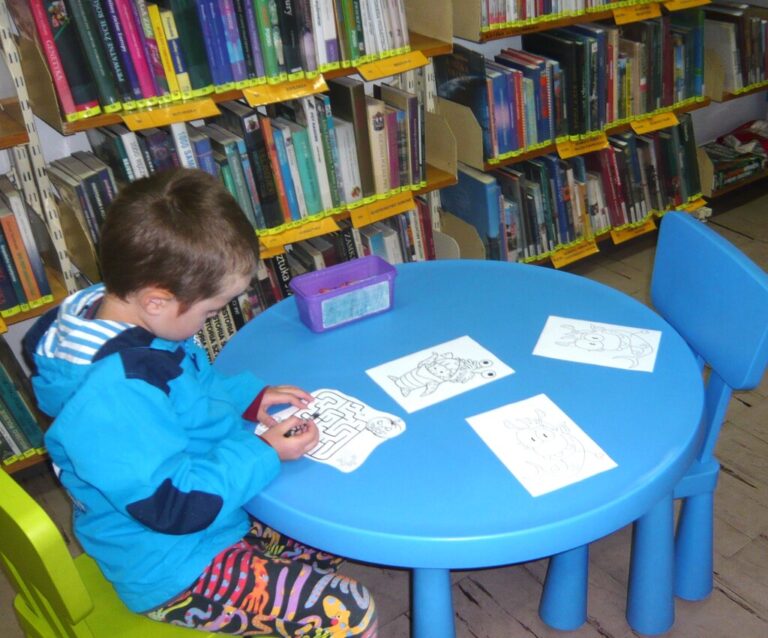 dziecko przy stoliku koloruje