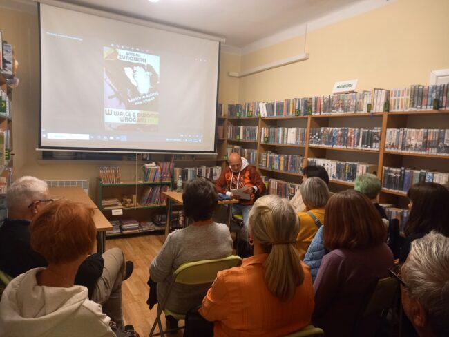 spotkanie varsavianistyczne; uczestnicy zapoznają się z prezentacją multimedialną wyświetlaną na ekranie projektora