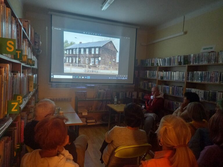 spotkanie varsavianistyczne; uczestnicy zapoznają się z prezentacją multimedialną wyświetlaną na ekranie projektora