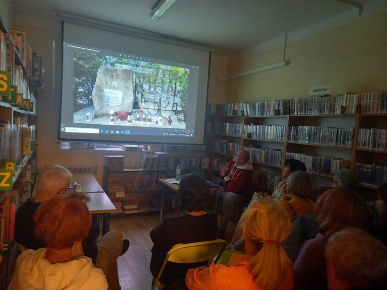 spotkanie varsavianistyczne; uczestnicy zapoznają się z prezentacją multimedialną wyświetlaną na ekranie projektora