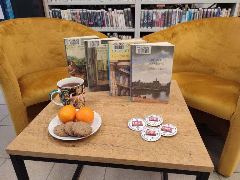 książki na stoliku, obok ciasteczka i owoce na talerzu