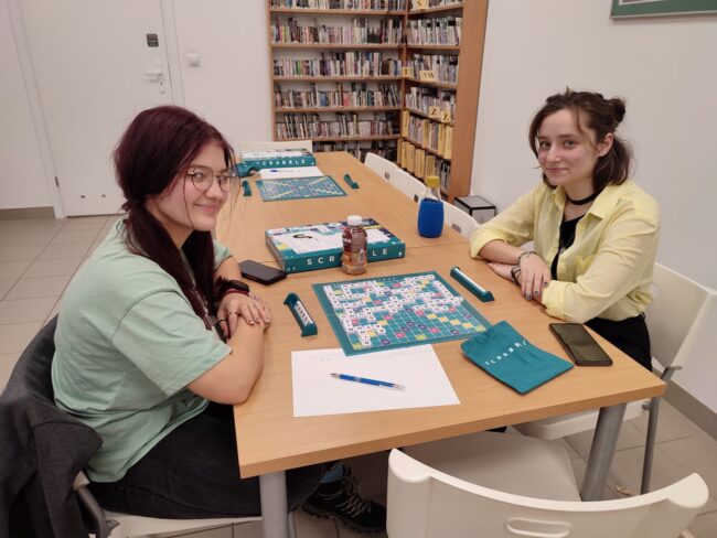 czytelnicy grają w scrabble w bibliotece